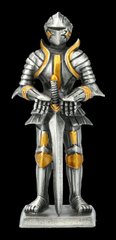 Фігура олов'яного лицаря спирається на меч